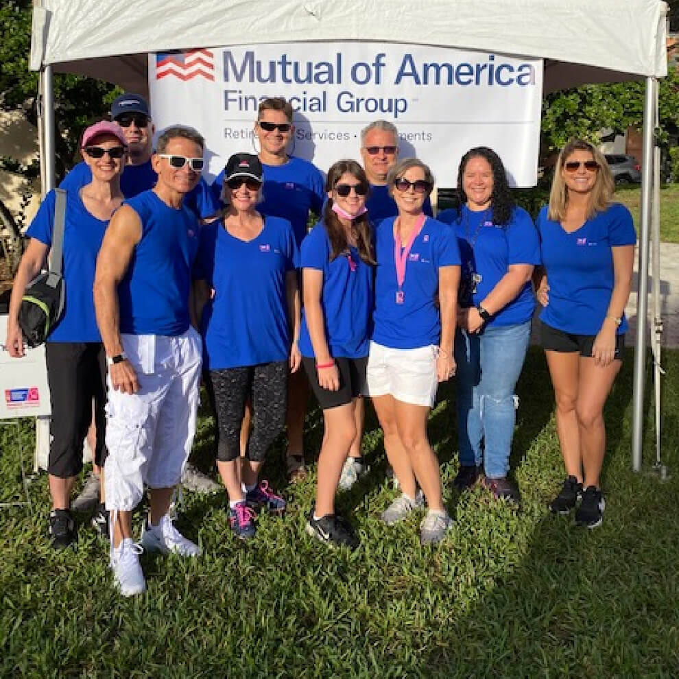 Group of Mutual of America employees posing in front of a tent at the American Cancer Society’s Making Strides Against Breast Cancer Walk